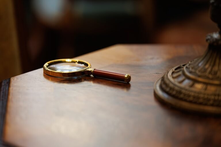 Magnifying glass on a wooden desk in a detective-style investigation setting