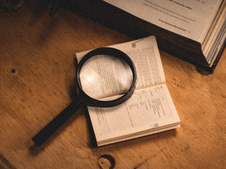 Magnifying glass on an open book representing careful cold case investigation